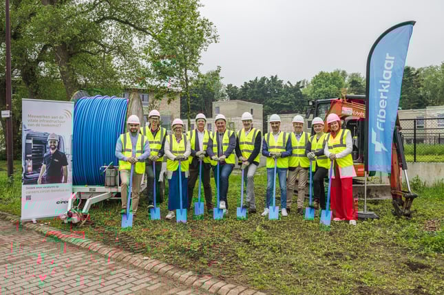 Fiberklaar steekt spade in de grond voor glasvezelaanleg in Oudenburg